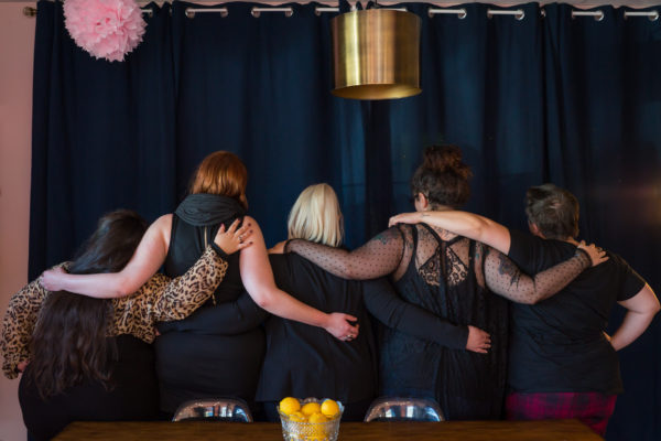 A group of women gather at a feminist co-working space and spend time talking, connecting and collaborating at a networking event.